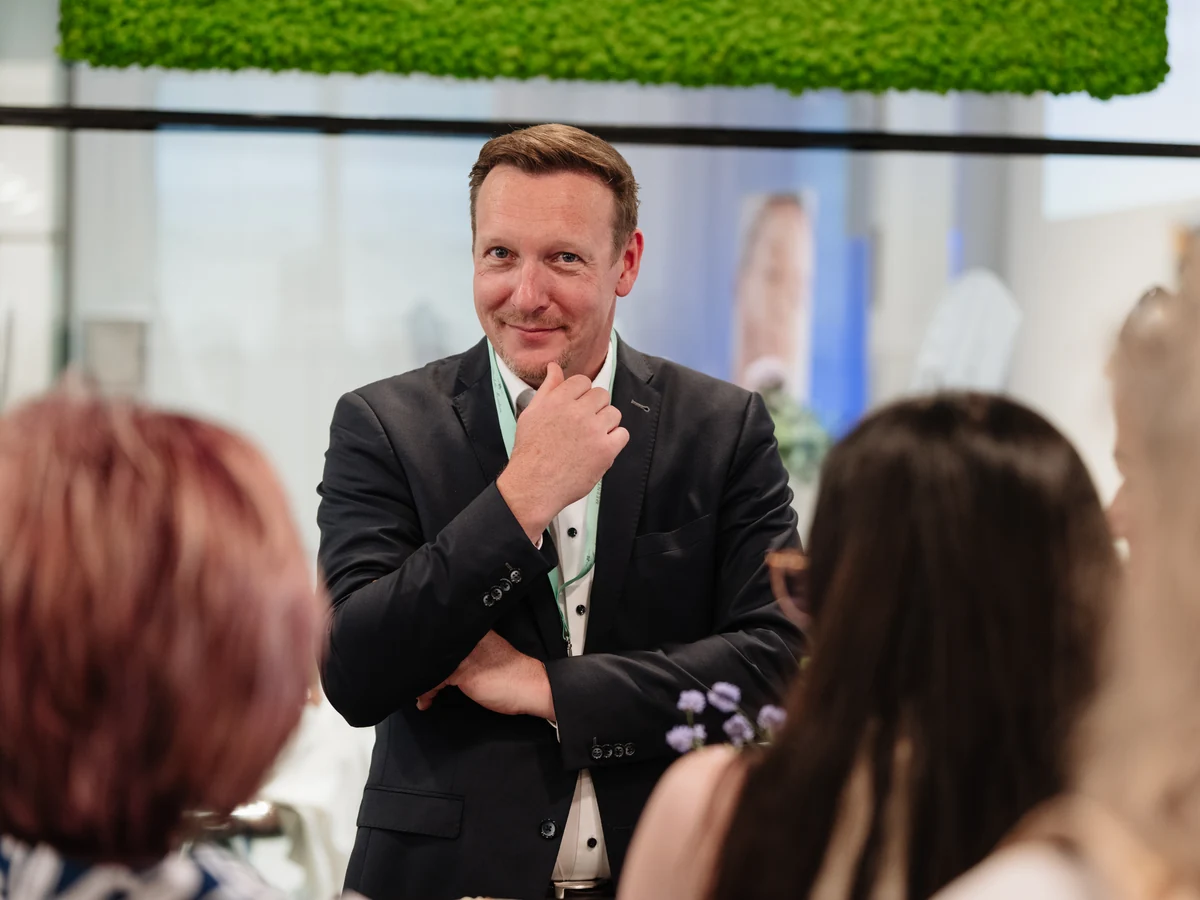 Thomas Pretschner im Austausch mit mehreren Teilnehmerinnen beim Kosmetik-Kongress